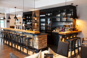 Restaurant "LE DAYO" in Bocholt, Theke, Schrankwand mit Gläsern, Rustikales Holz mit Schwarz und Akzentbeleuchtung