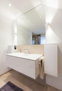 Wohnraum, Badezimmer in Weiß, mit deckenhohen Spiegel, Akzentbeleuchtung, Deckeneinbauleuchten, Waschbecken, Marmor
